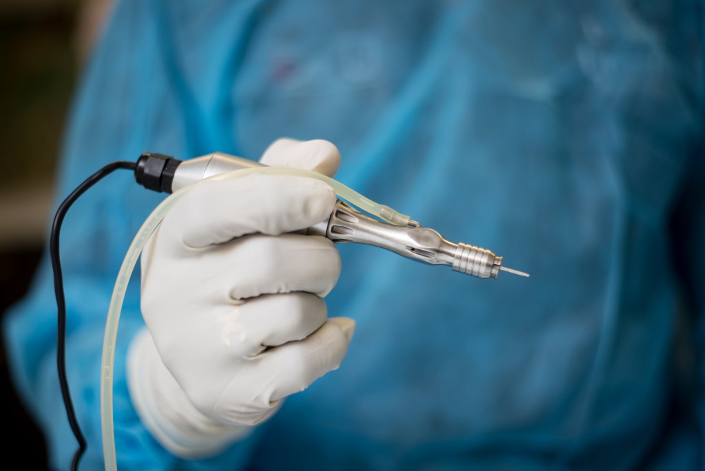 Modern Hair transplant Surgery Methods : Dr U holding UGraft advance FUE handheld electromechanical device